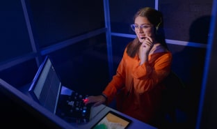 Alumna de la escuela de comunicaciones de Cibertec trabajando en la sala de producción y edición.