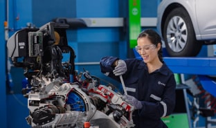 Alumna de la escuela de ingeniería de Cibertec realizando mantenimiento de maquinaria automotriz.